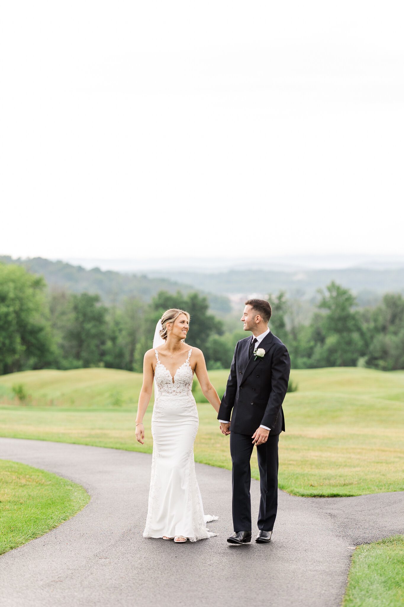 Bride and groom walk hand in hand through SkyView Golf Club after their first look