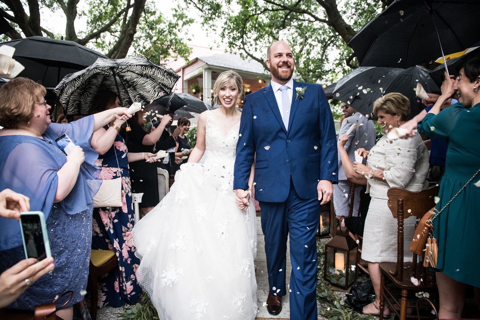 Bride and groom walk down aisle at Compass Point wedding in drizzle