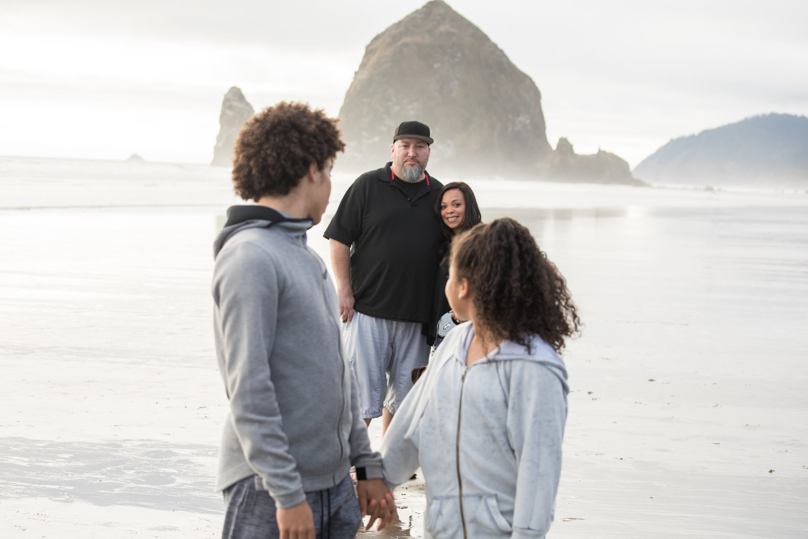 cannon beach family kids looking at parents Haystack Rock in background
