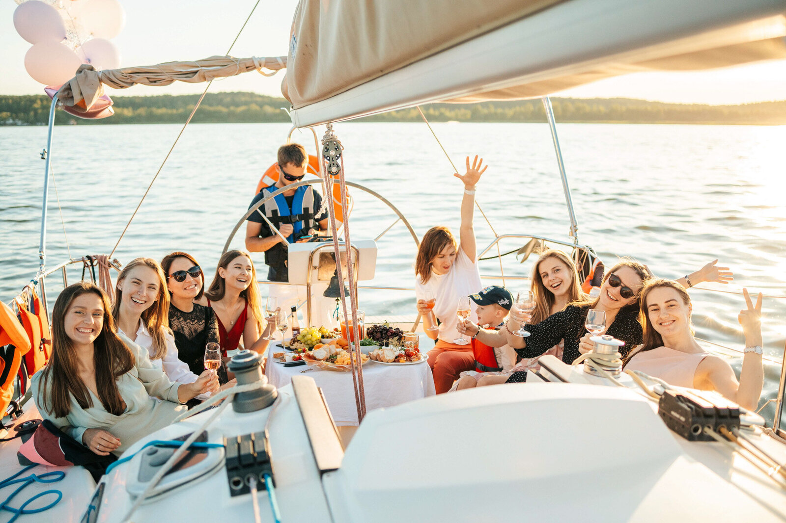 Group of friends having fun and sailing in the ocean through a yacht