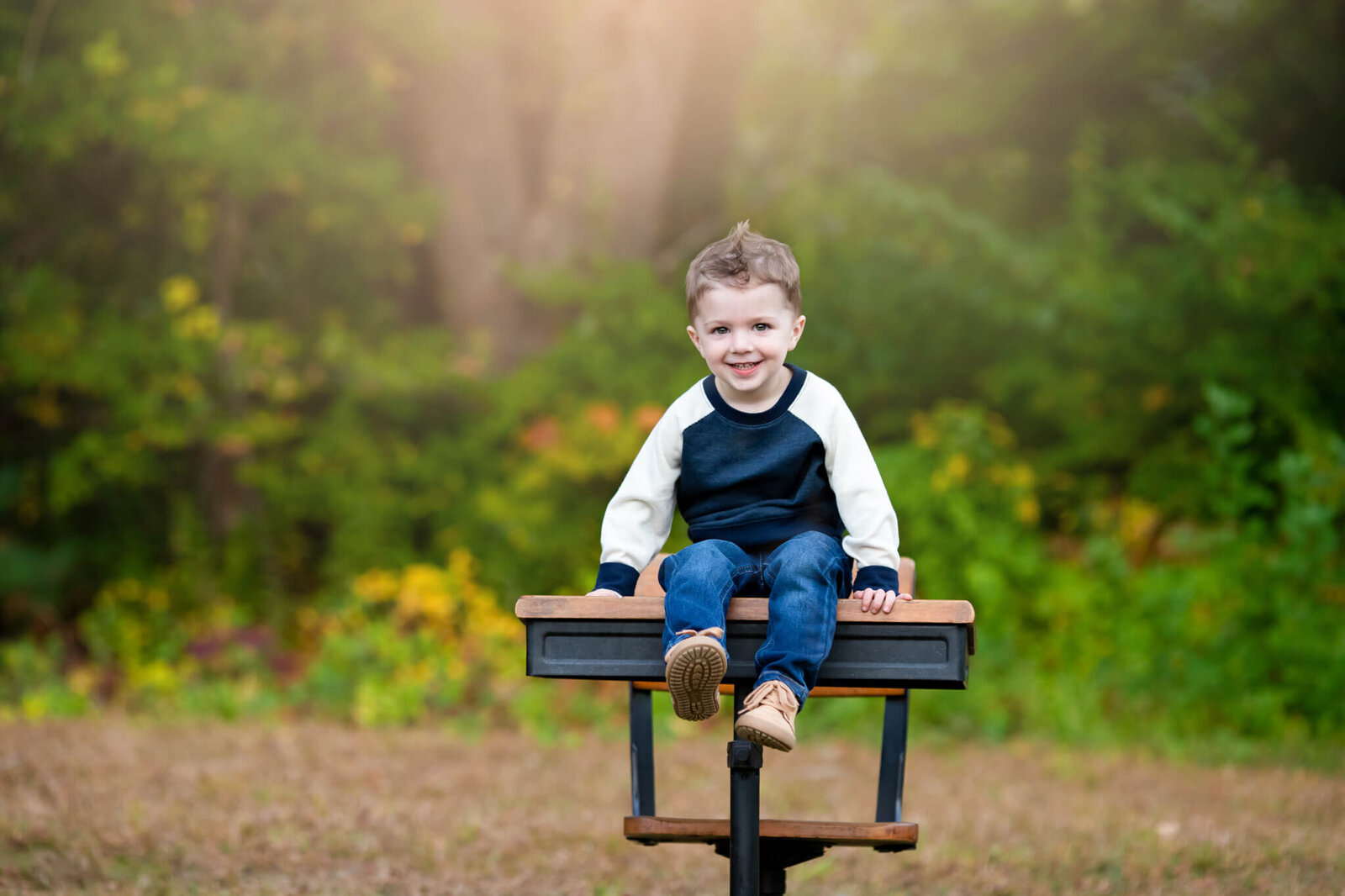 Back to school picture of little boy sitting on a desk