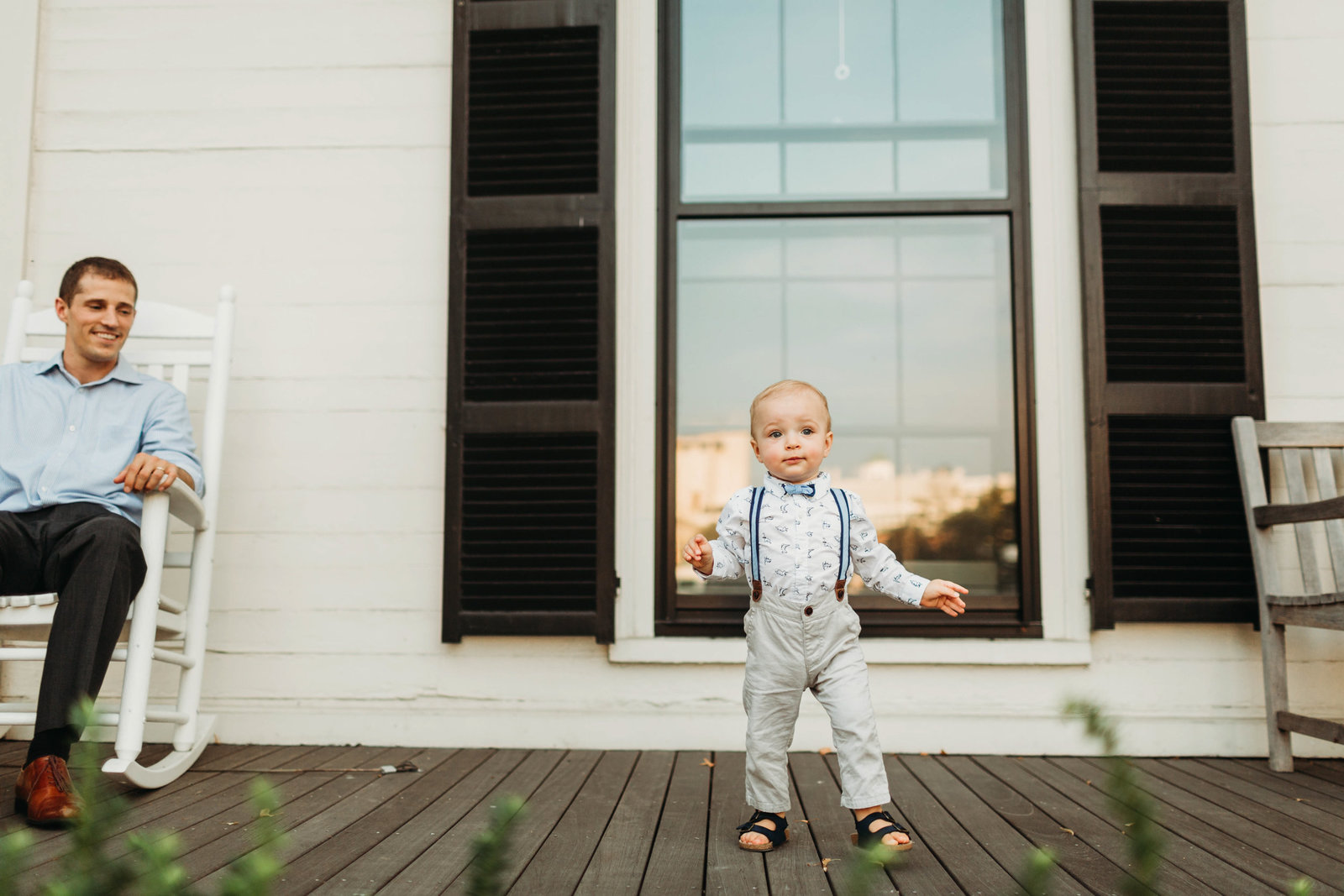 toddler boy in suspenders walks towards camera in cambridge ma