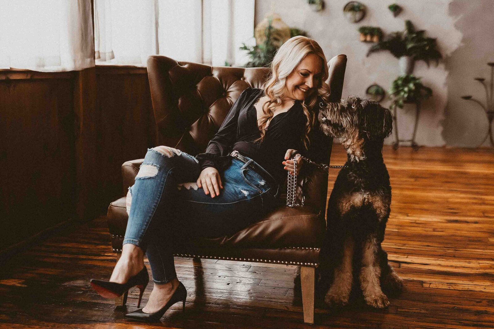 woman sitting on a chair with dog beside her