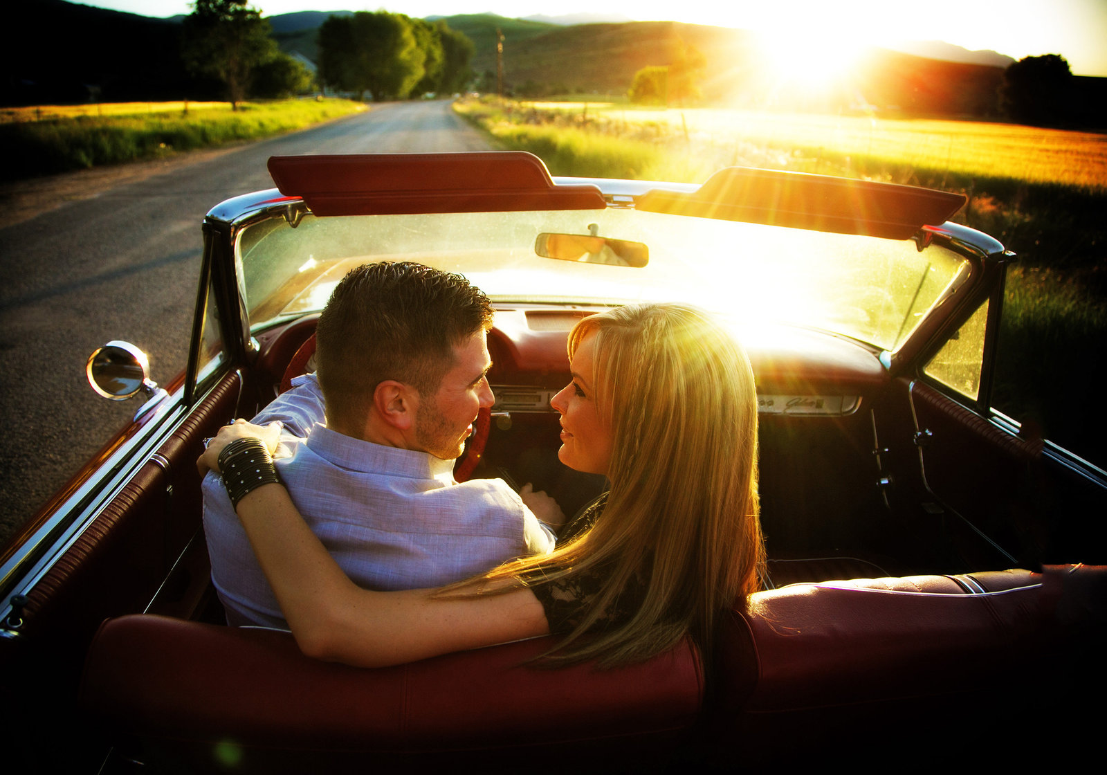 Engagement couple with car at sunset