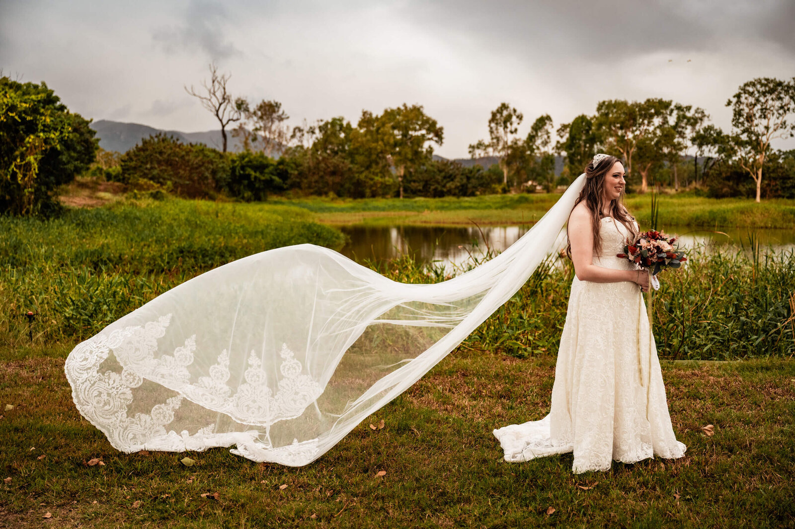 In a picturesque field, a bride's veil dances in the wind, symbolizing elegance and the joy of her special day.