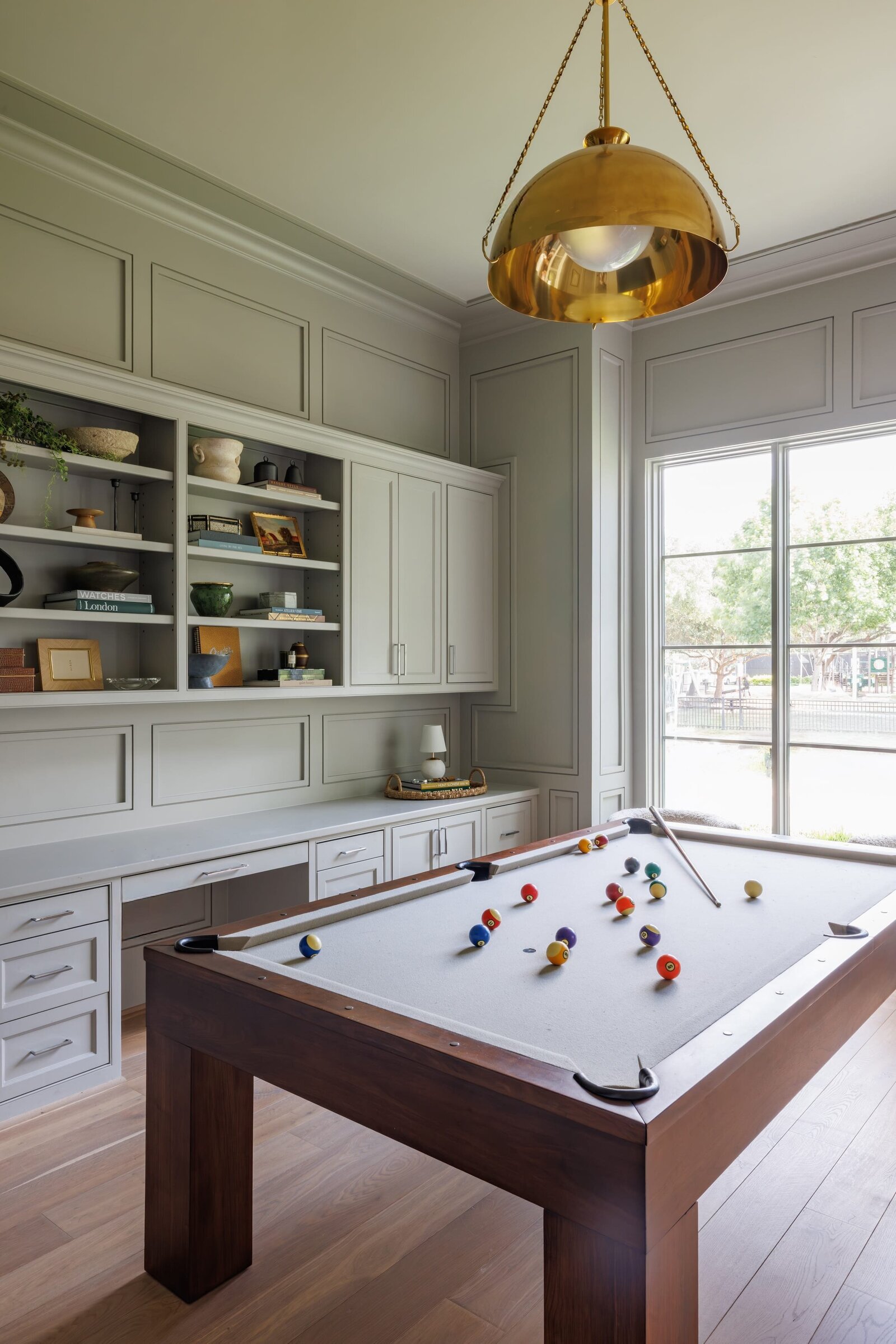 vision and hammer interior design pool table with gold hanging lamp and large window