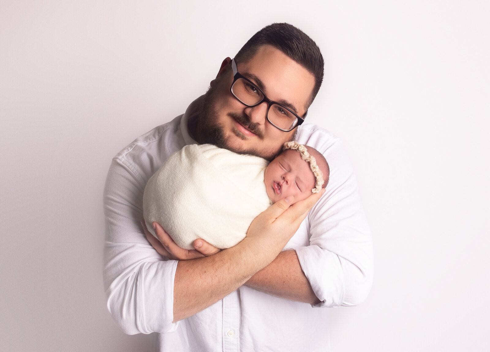 Dad holding baby girl, during newborn photoshoot with Nashville, TN newborn photographer
