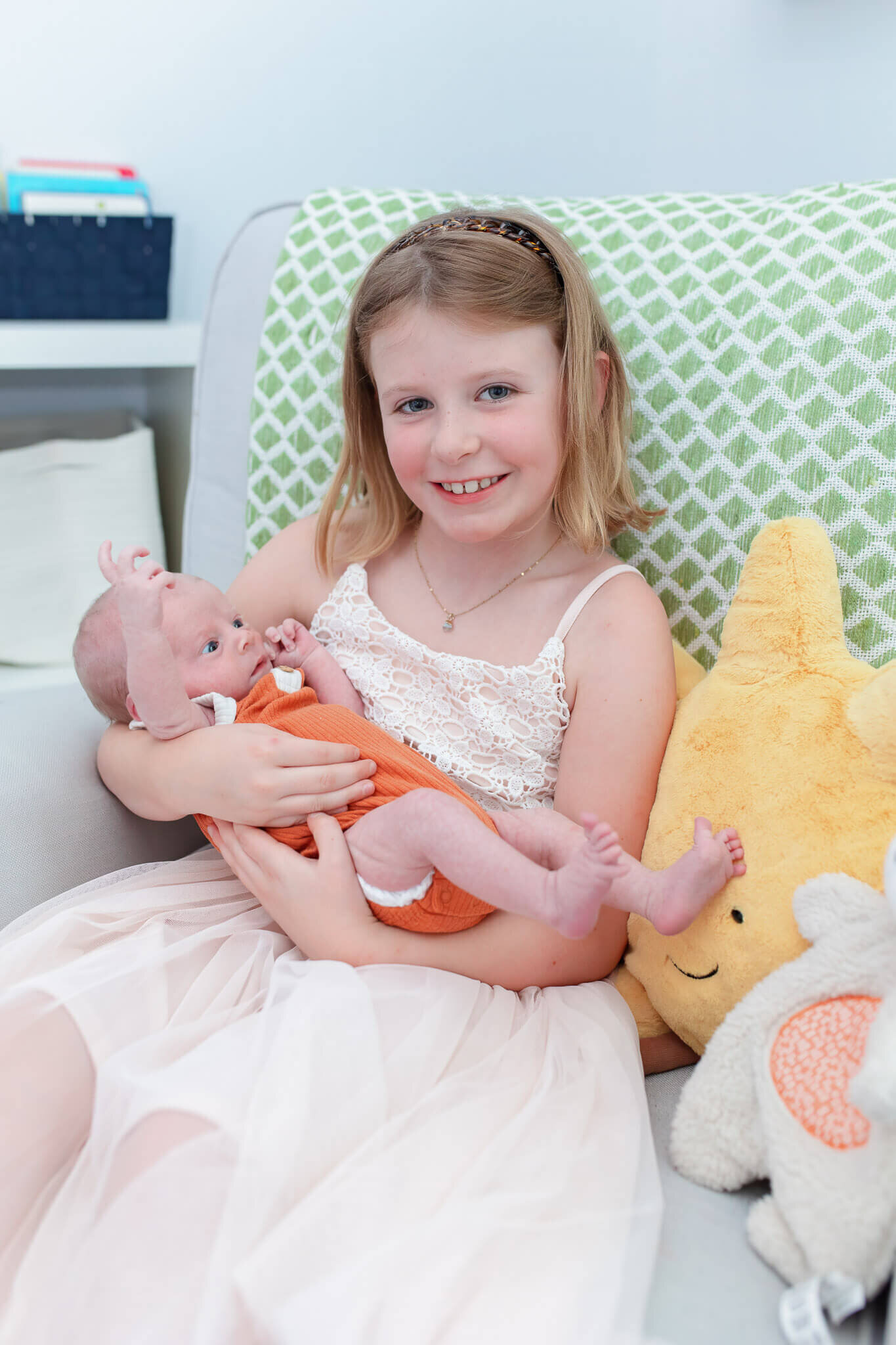 A newborn boy being held by his big sister.