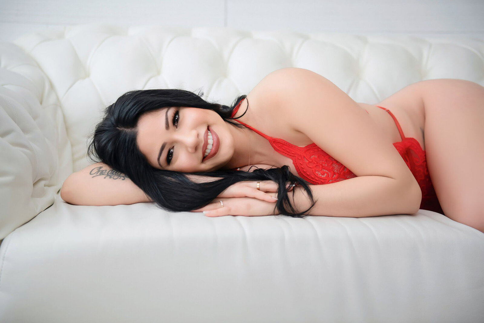 Young woman in red lace lingerie posing for boudoir portrait