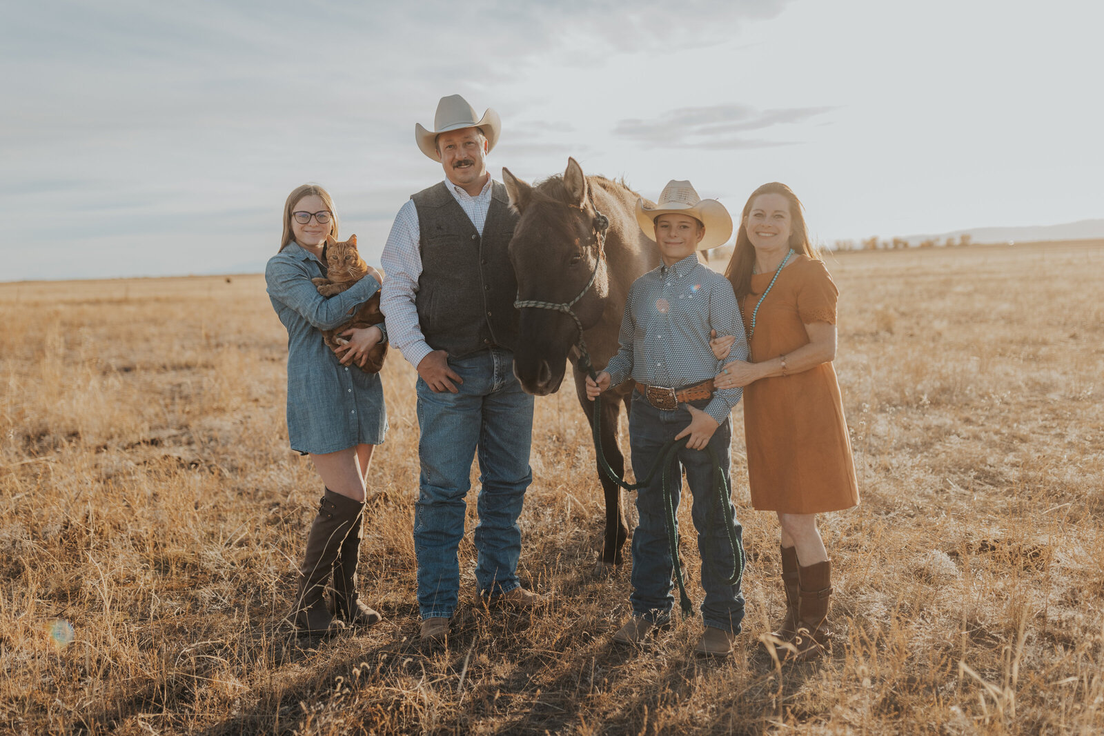 Family poses with cat and horse on their colorado acreage