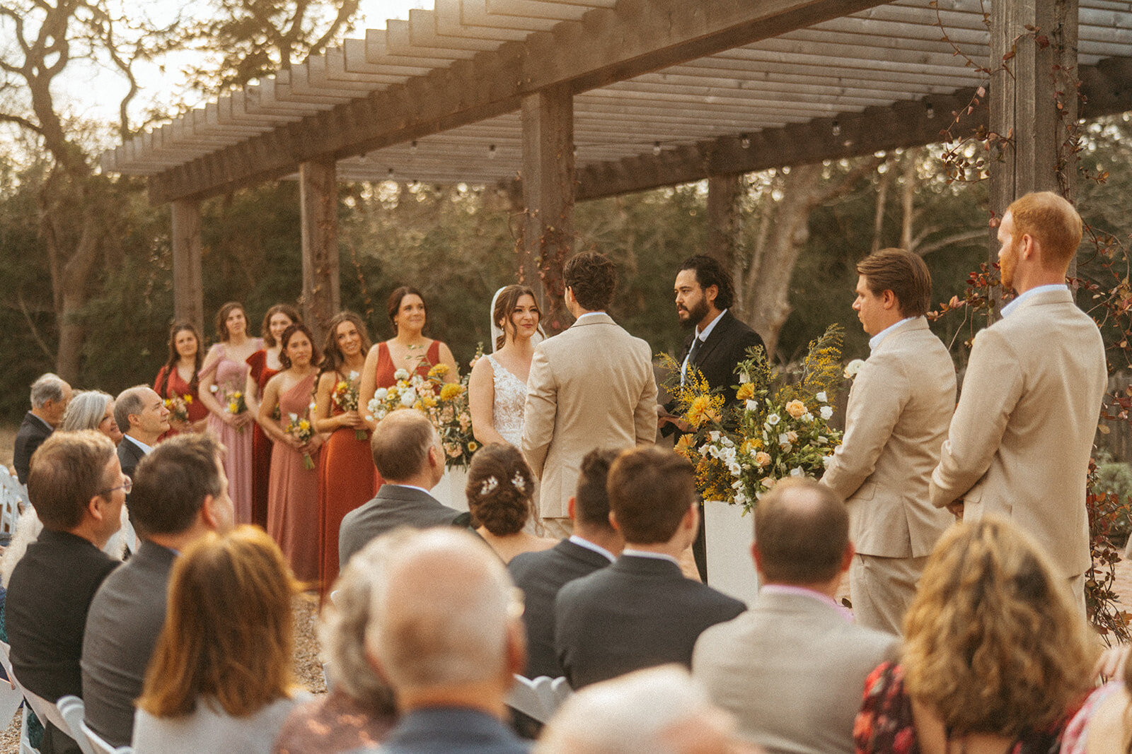 Outdoor wedding ceremony under the pergola in The Grand Lady's flower garden