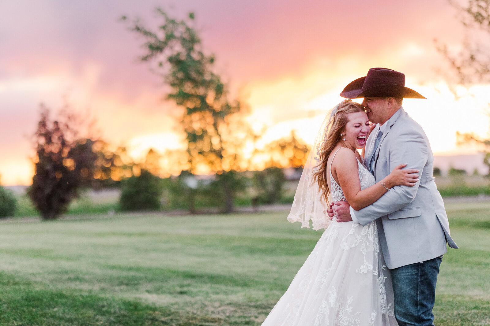 Candid photo of the bride and groom laughing together during golden hour at their Loma wedding