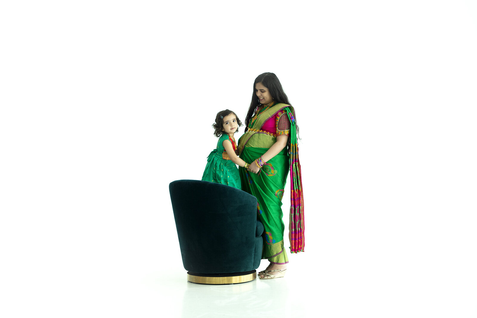 Mother and daughter wearing traditional Indian clothing pose at Maternity photoshoot.