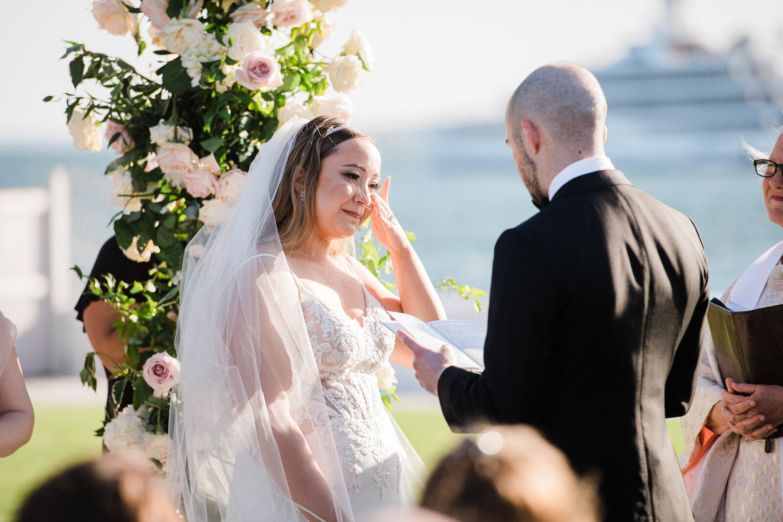bride wipe tears at outdoor altar