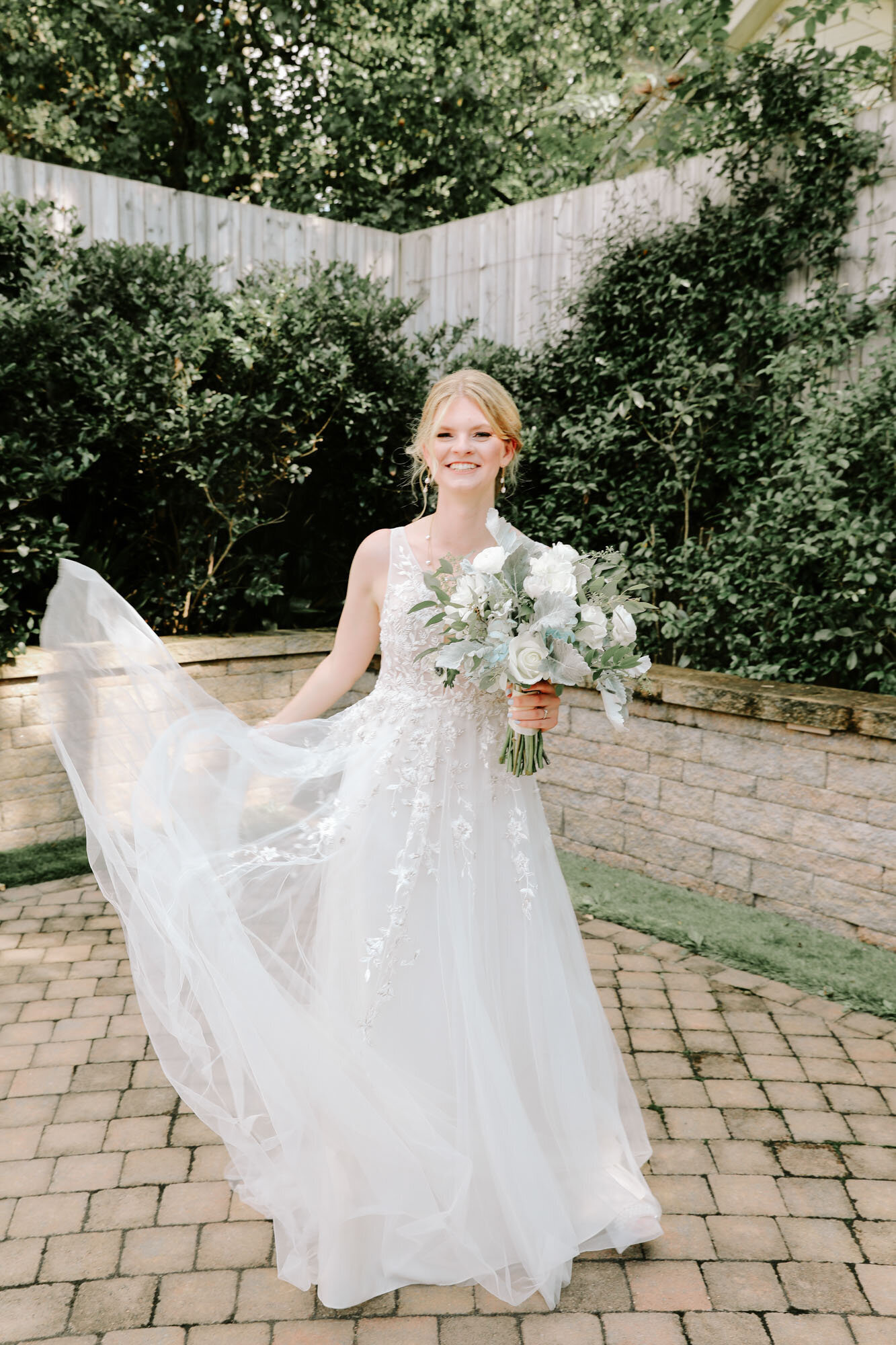 Bride smiling with bouquet outside of North Carolina wedding