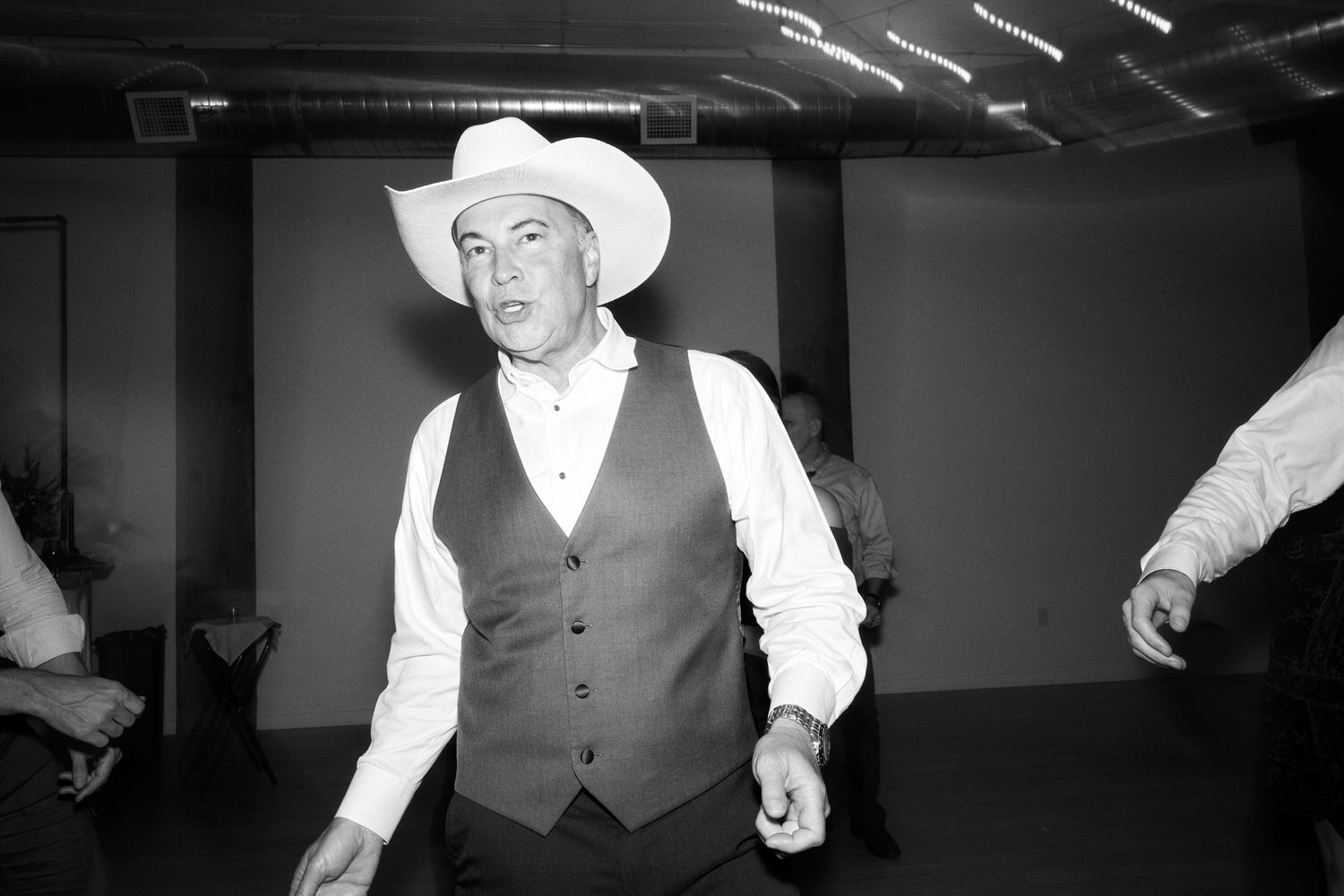 Father of the groom in a cowboy hat dances.