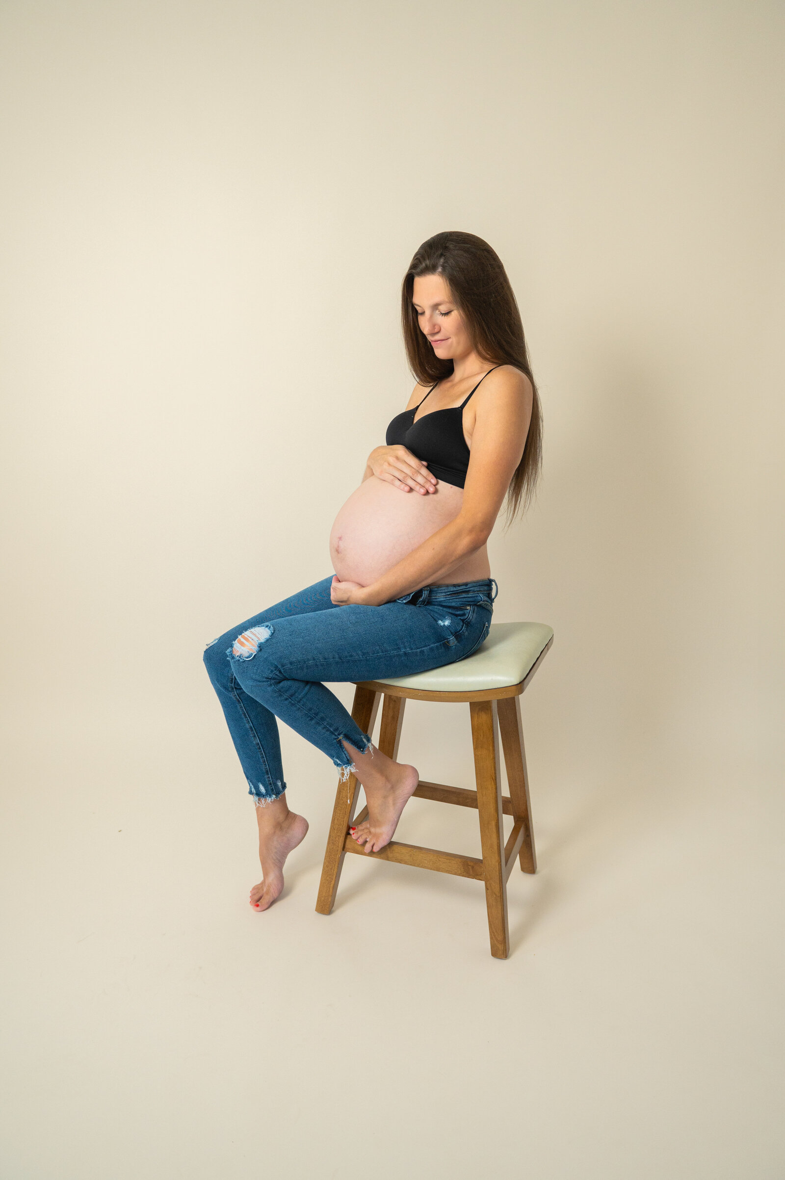 pregnant mom on a stool  during a photoshoot