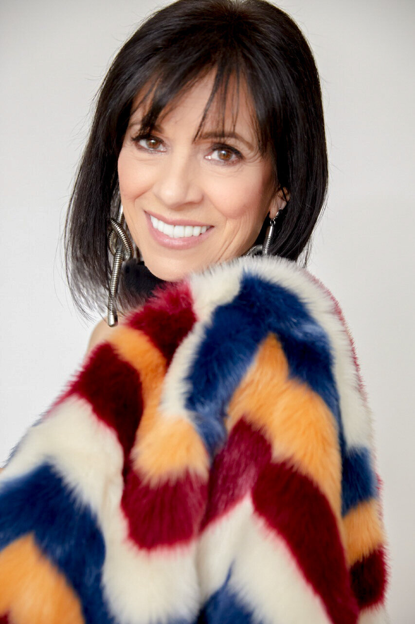 Isabella looking over shoulder wearing colorful jacket