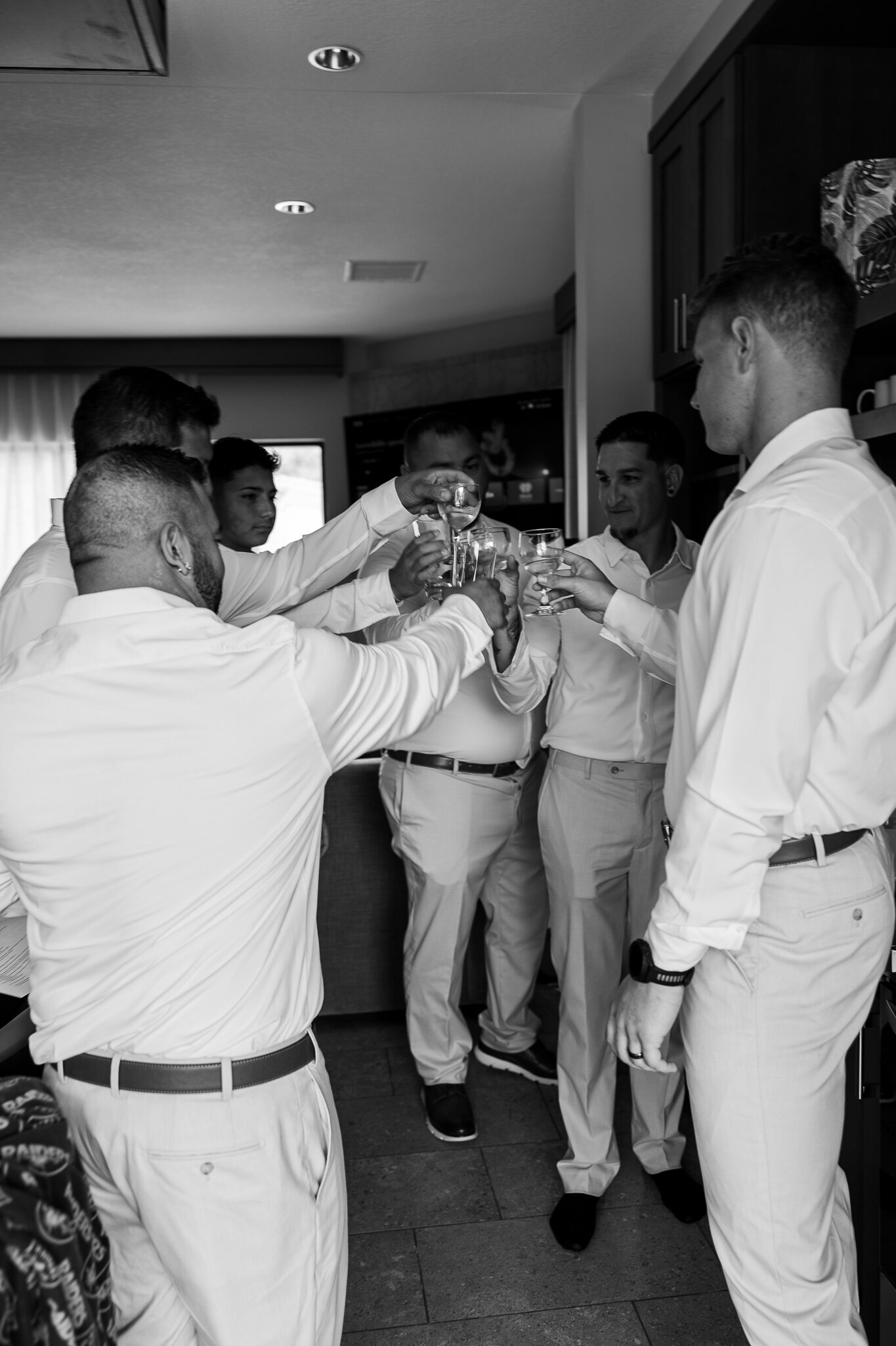 Groomsmen cheering with drinks getting ready for the wedding at the Red Earth Venue 