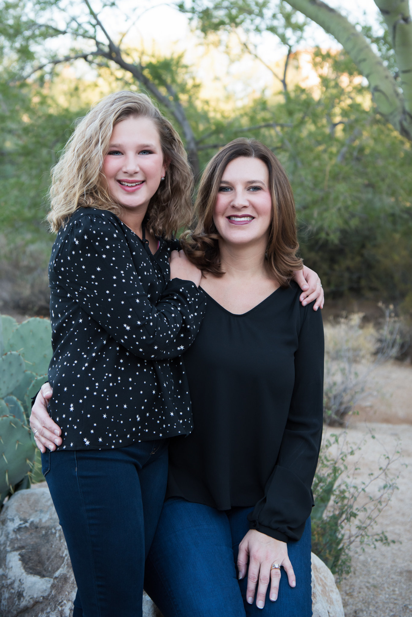 mom and teen daughter have their arms wrapped around each other and smiling