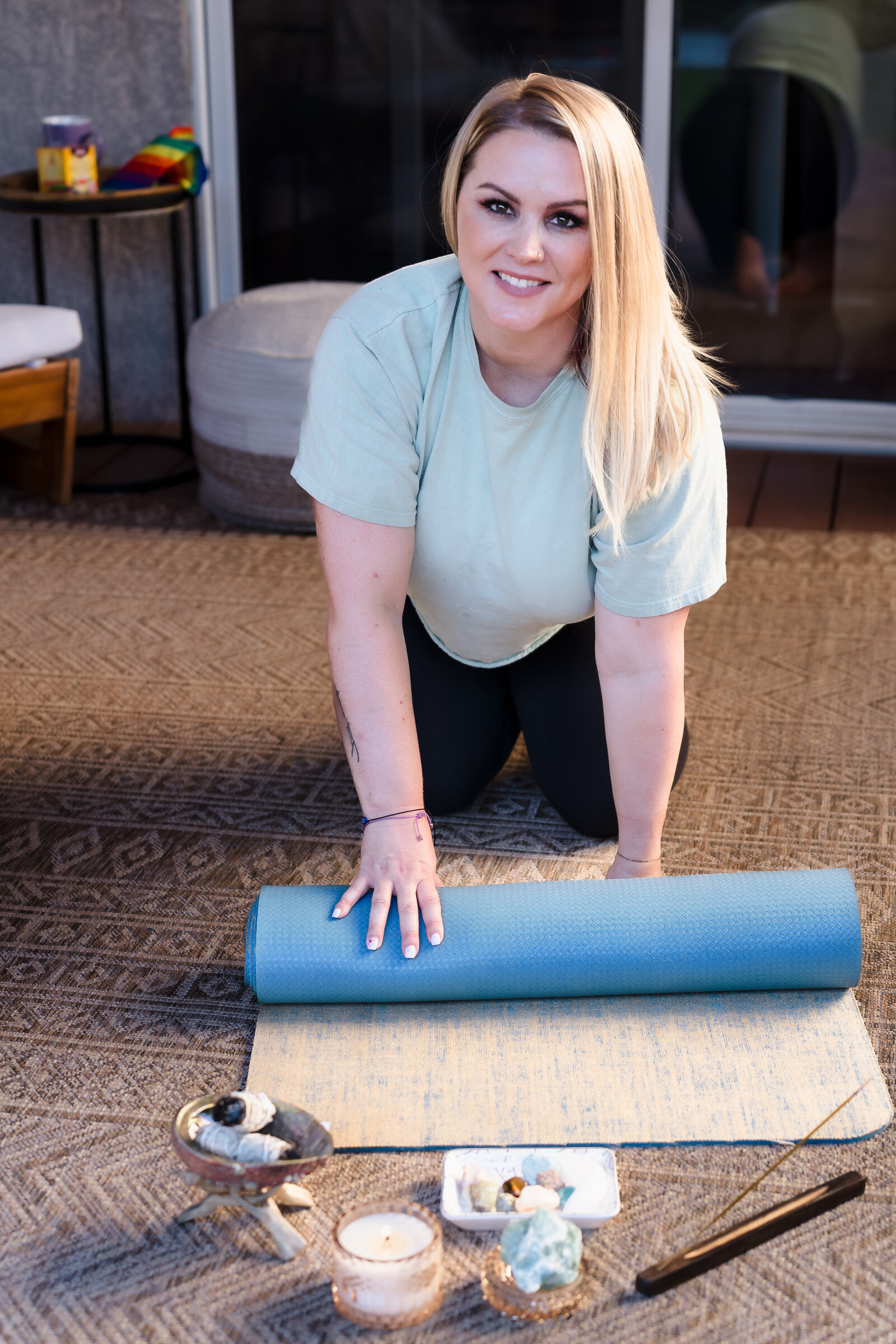 life coach in a yoga pose, along with mat and meditation props