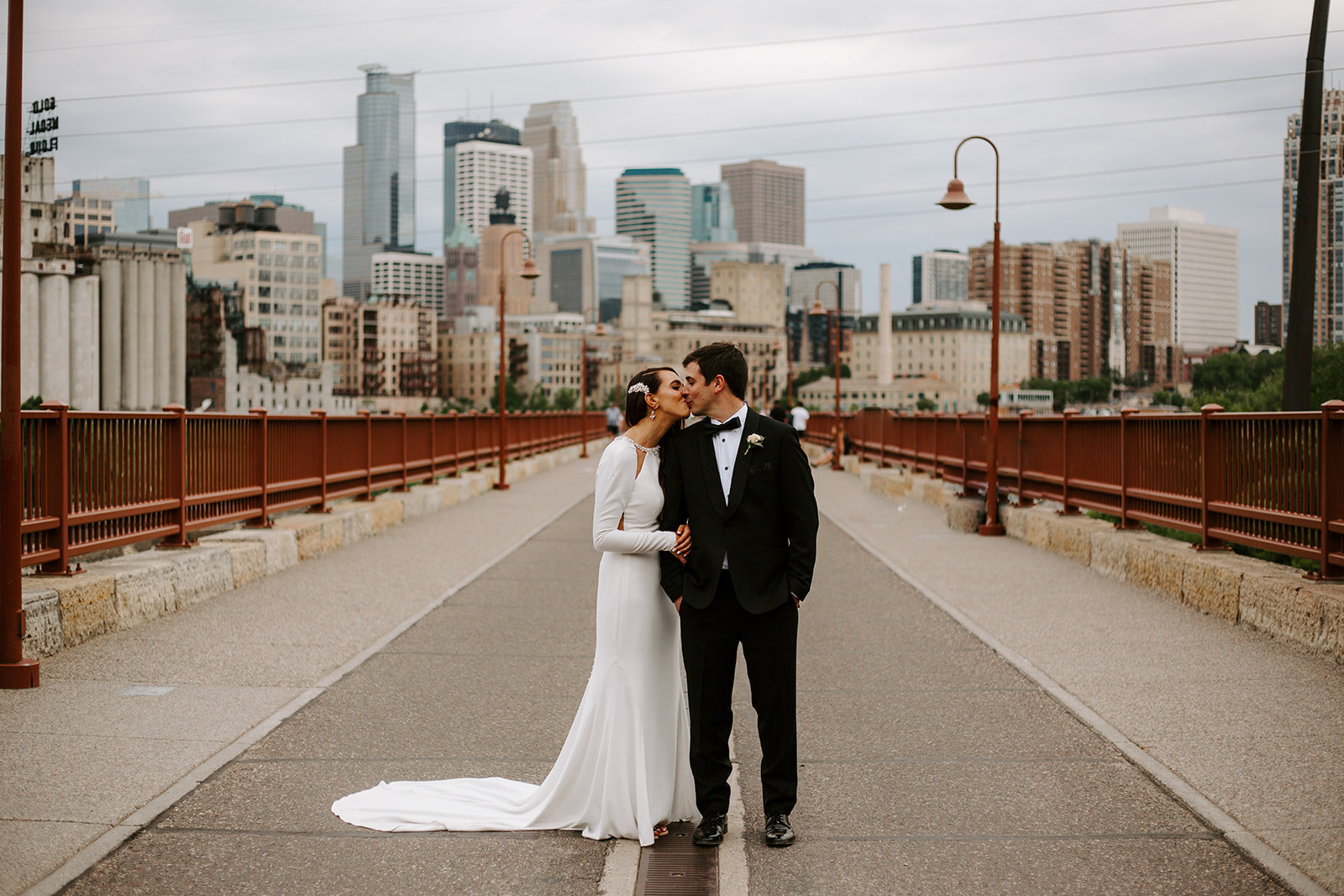 Bride and groom sharing a kiss on the Stone Arch Bridge in Minneaplis Minnesota during their wedding day