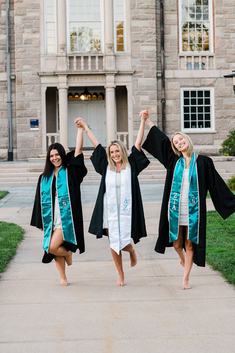 grad girls hold hands in alir waling