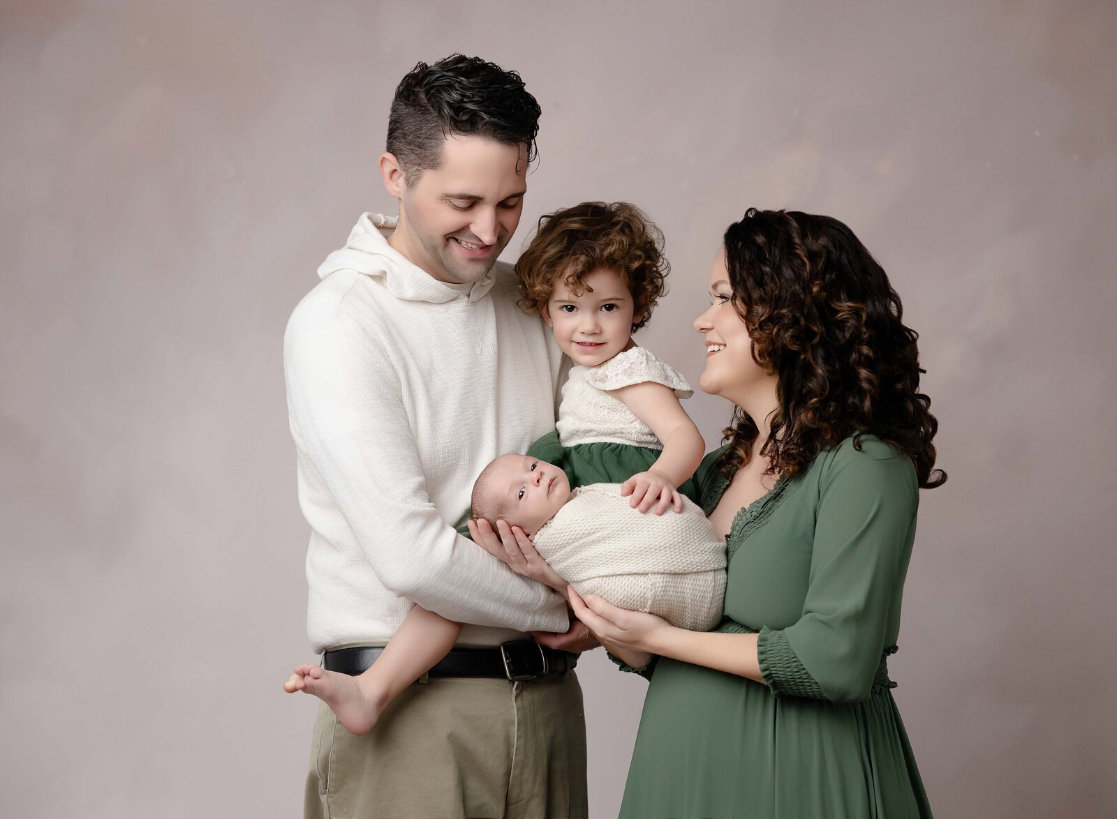 Newborn family portrait of everyone loving on baby boy. Photo taken at Marietta Portrait studio, located in Woodstock, GA.