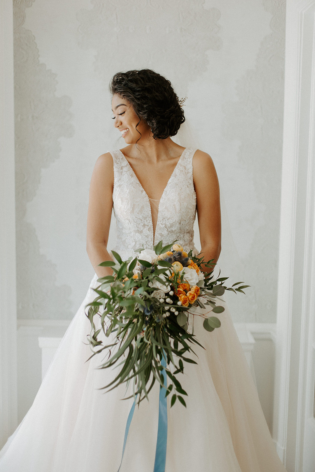 Bride smiling over her shoulder holding her bridal bouquet on her Minneapolis wedding day
