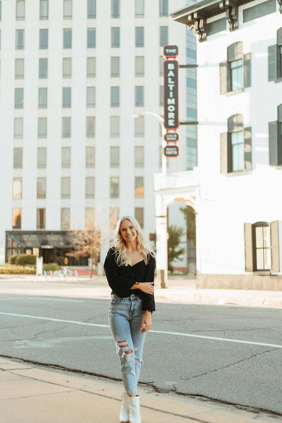 high school senior poses downtown for senior photos with ashley cole photography