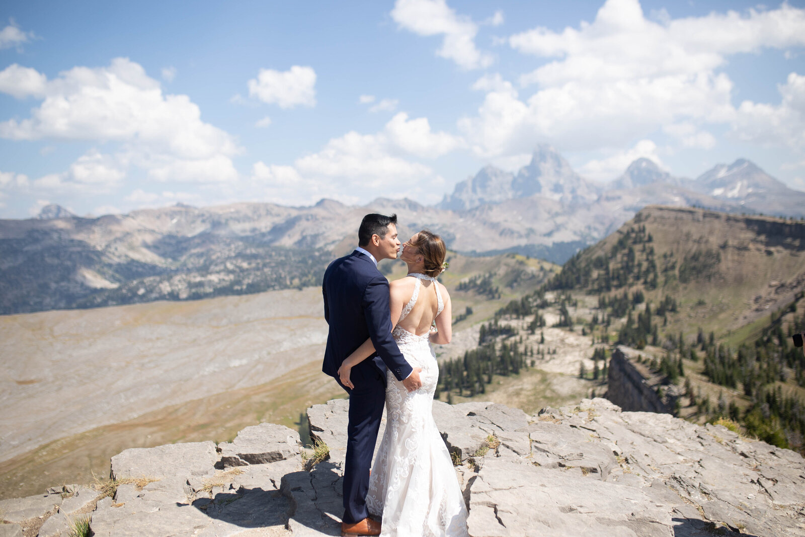 Grand Teton elopement with bride and groom looking out to the mountains while grabbing each others butts and looking at one another