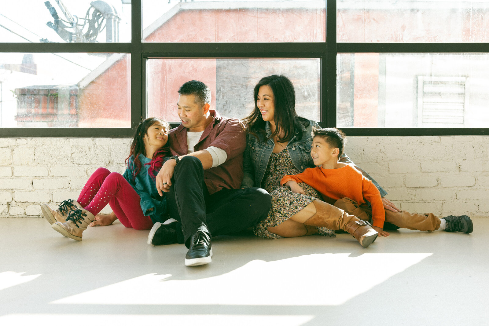 family of four sitting on floor in photo  studio