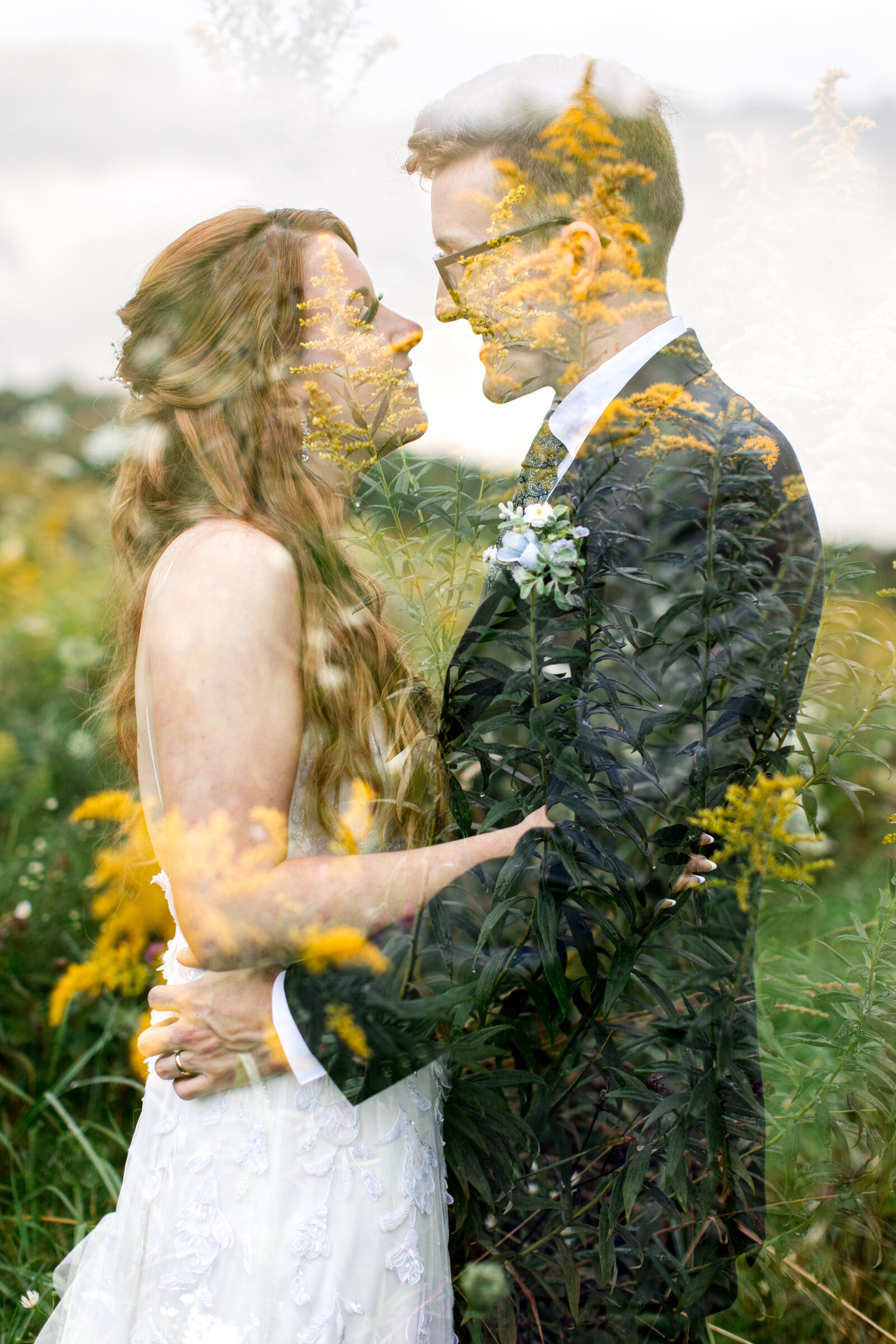 Wedding photo in Boone, NC of a bride & groom standing in a field of flowers smiling at each other. The photo is a double exposure.