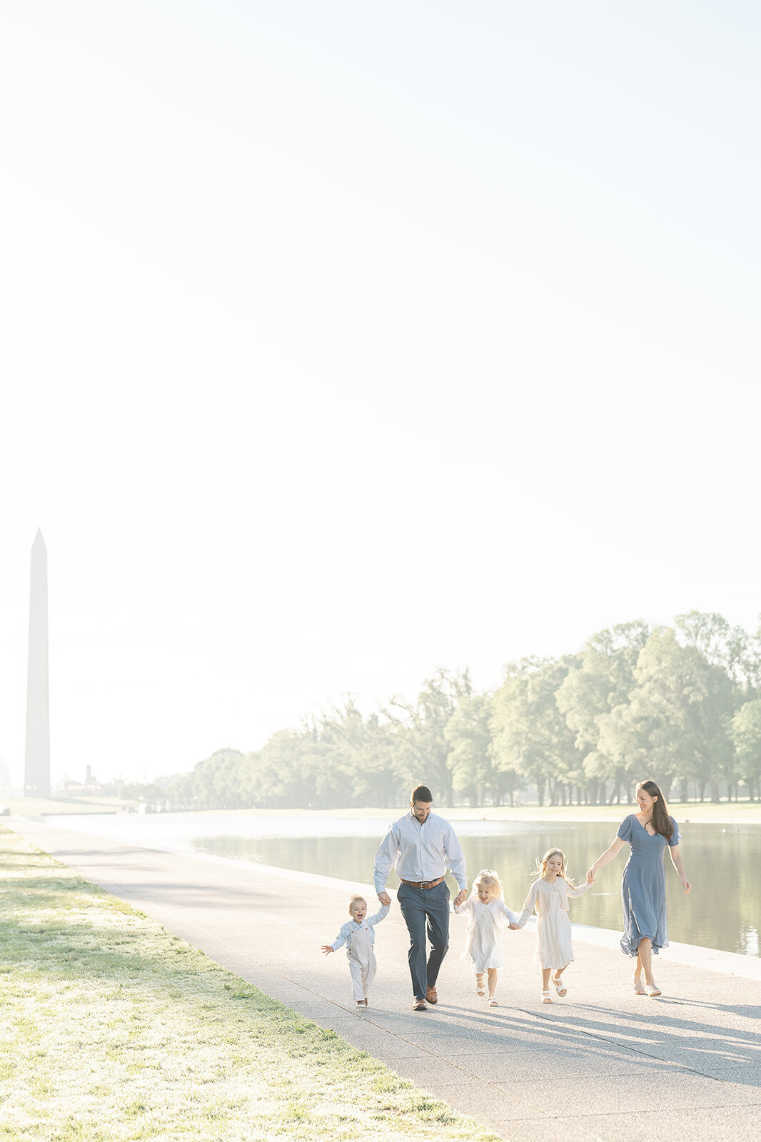 parents and kids run during Reflecting Pool family picture