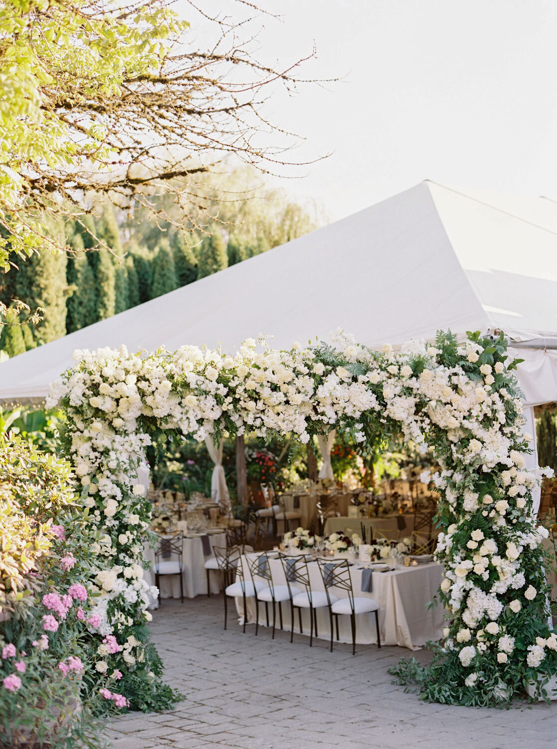 Floral decor surrounding an elegant reception tent