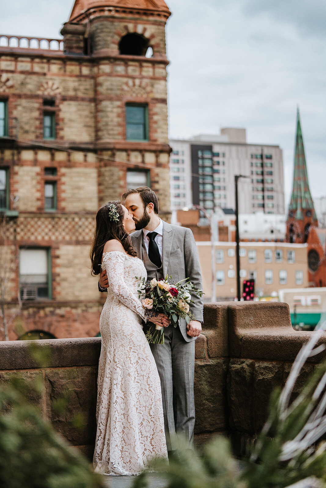 bride and groom kiss on boston rooftop after wedding