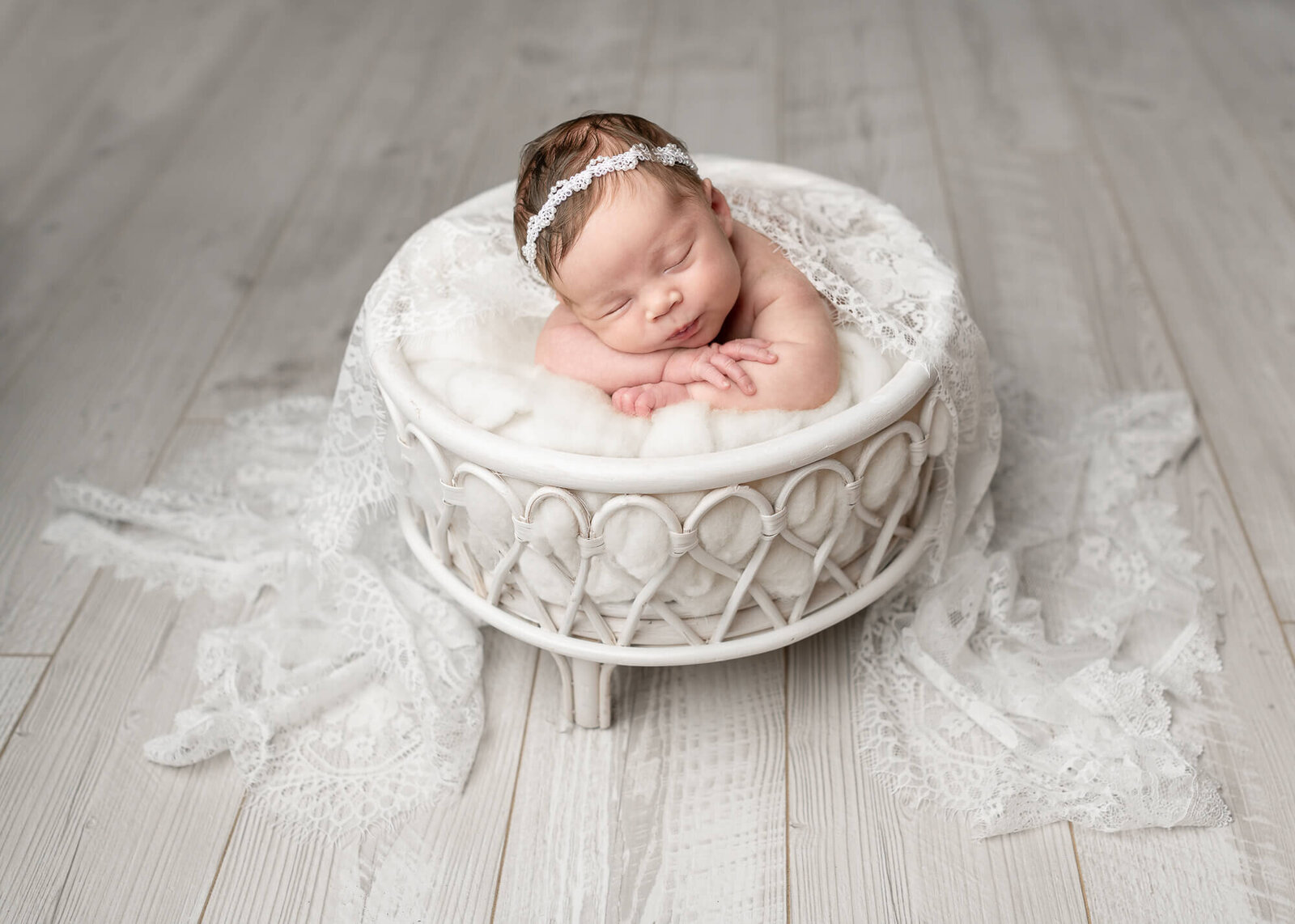 newborn picture resting in white basket