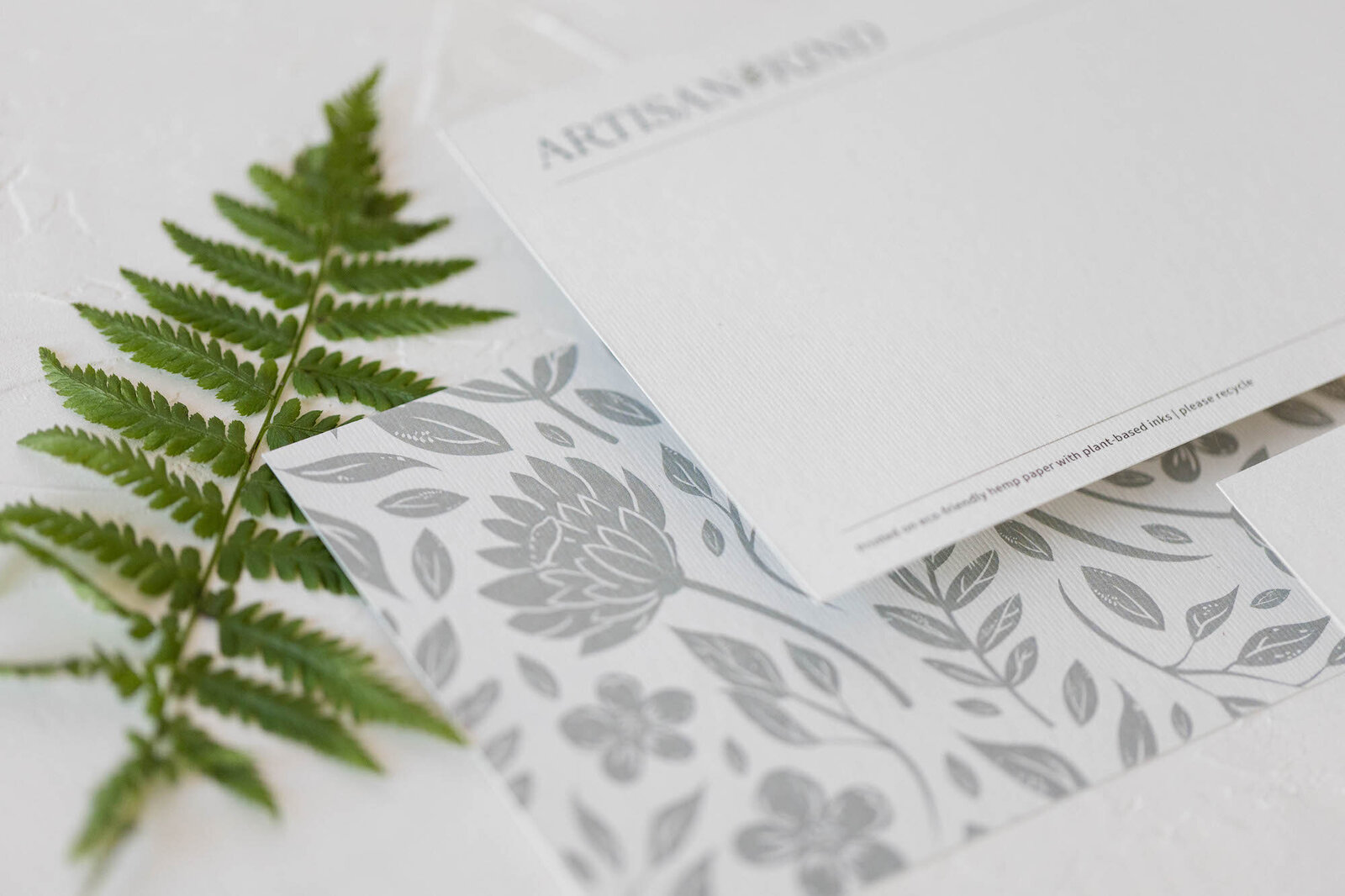 Fern next to floral branded note cards