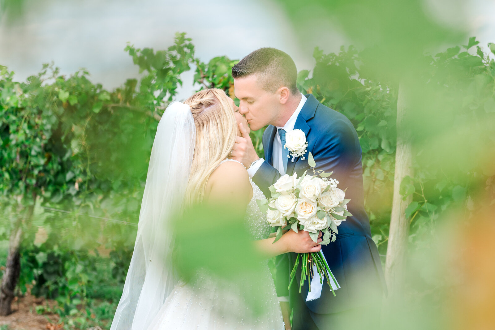 Lexington bride and groom snuggling in grapevine at Talon Winery