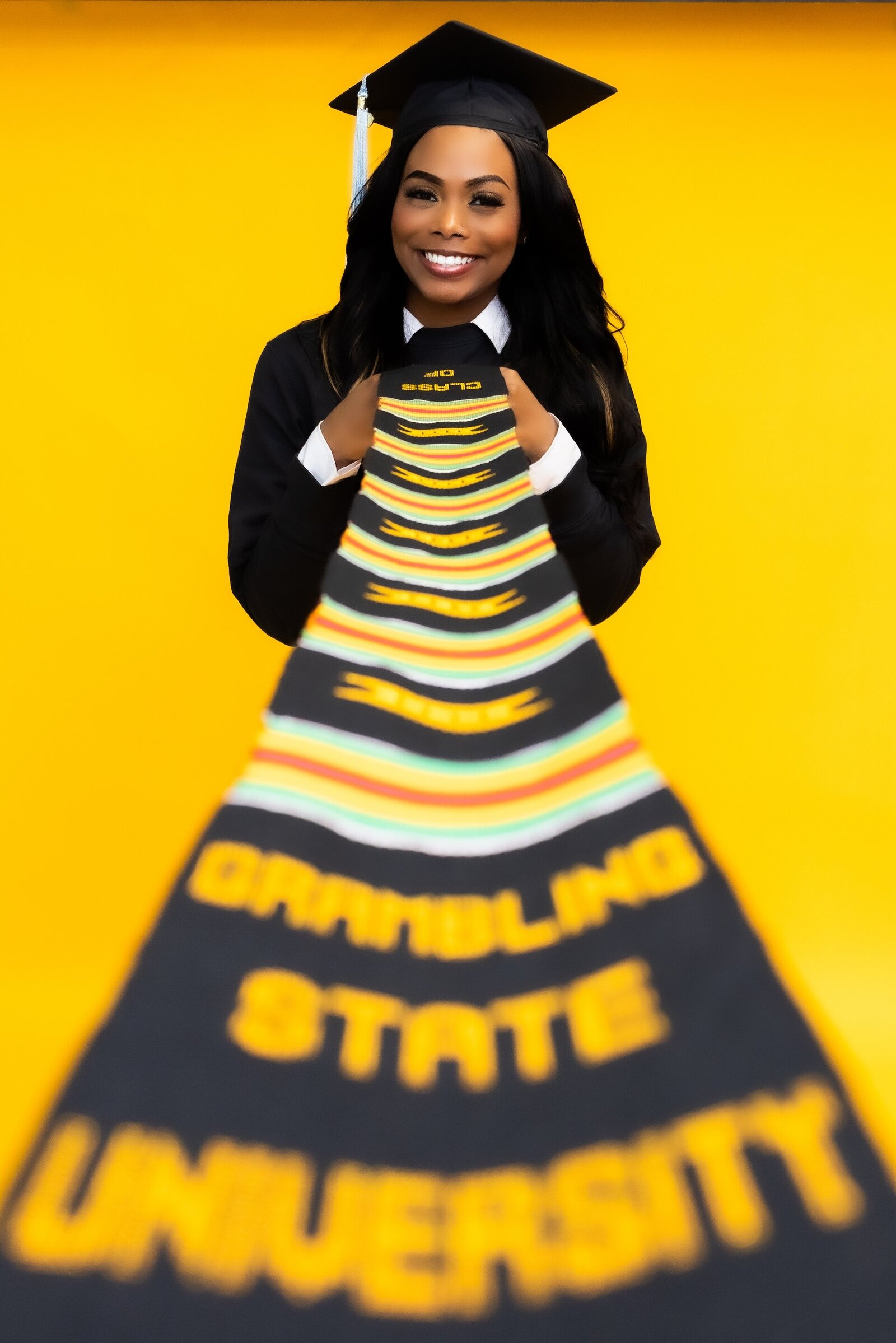 a woman in a grad cap holding a Grambling State University stole