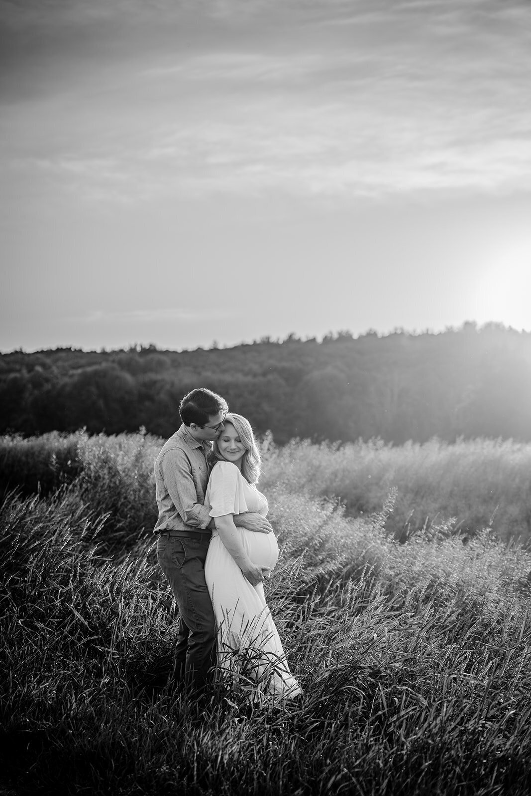black and white maternity photo in a field of long grass