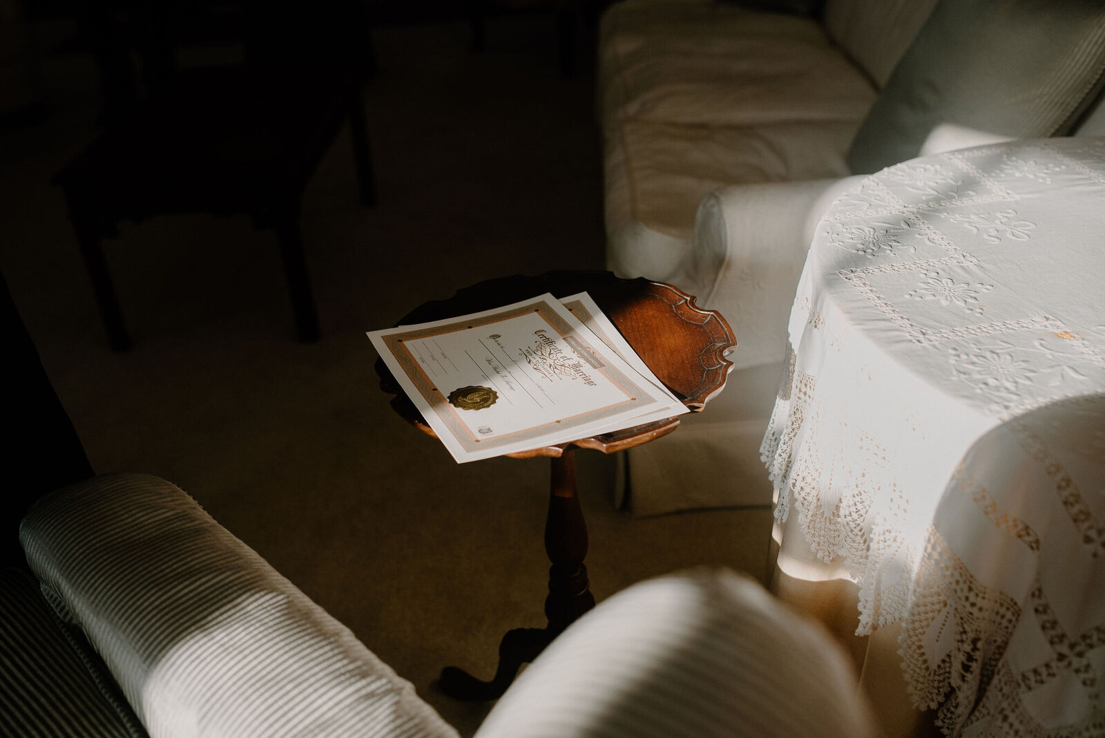 certificate of marriage license on side table with elegant wedding details