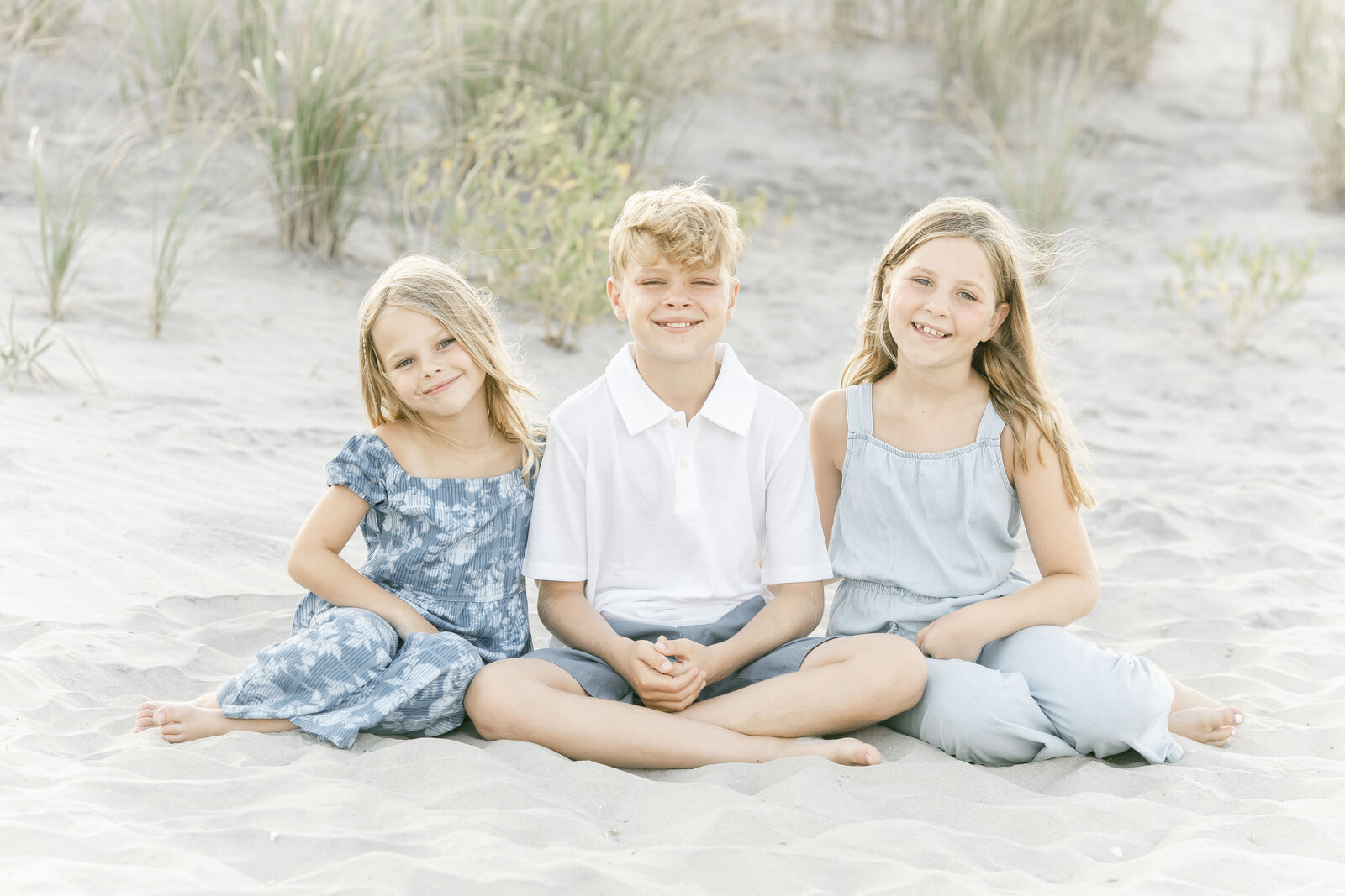 photo of three siblings sitting together on ocean city beach taken by ally kimpton 