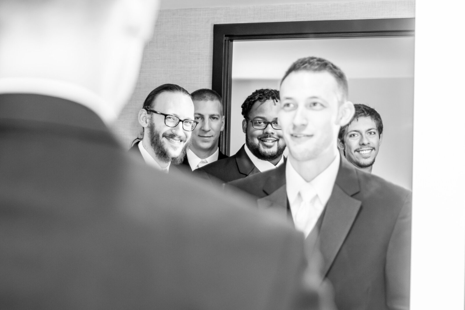 Groomsmen look at each other in the mirror