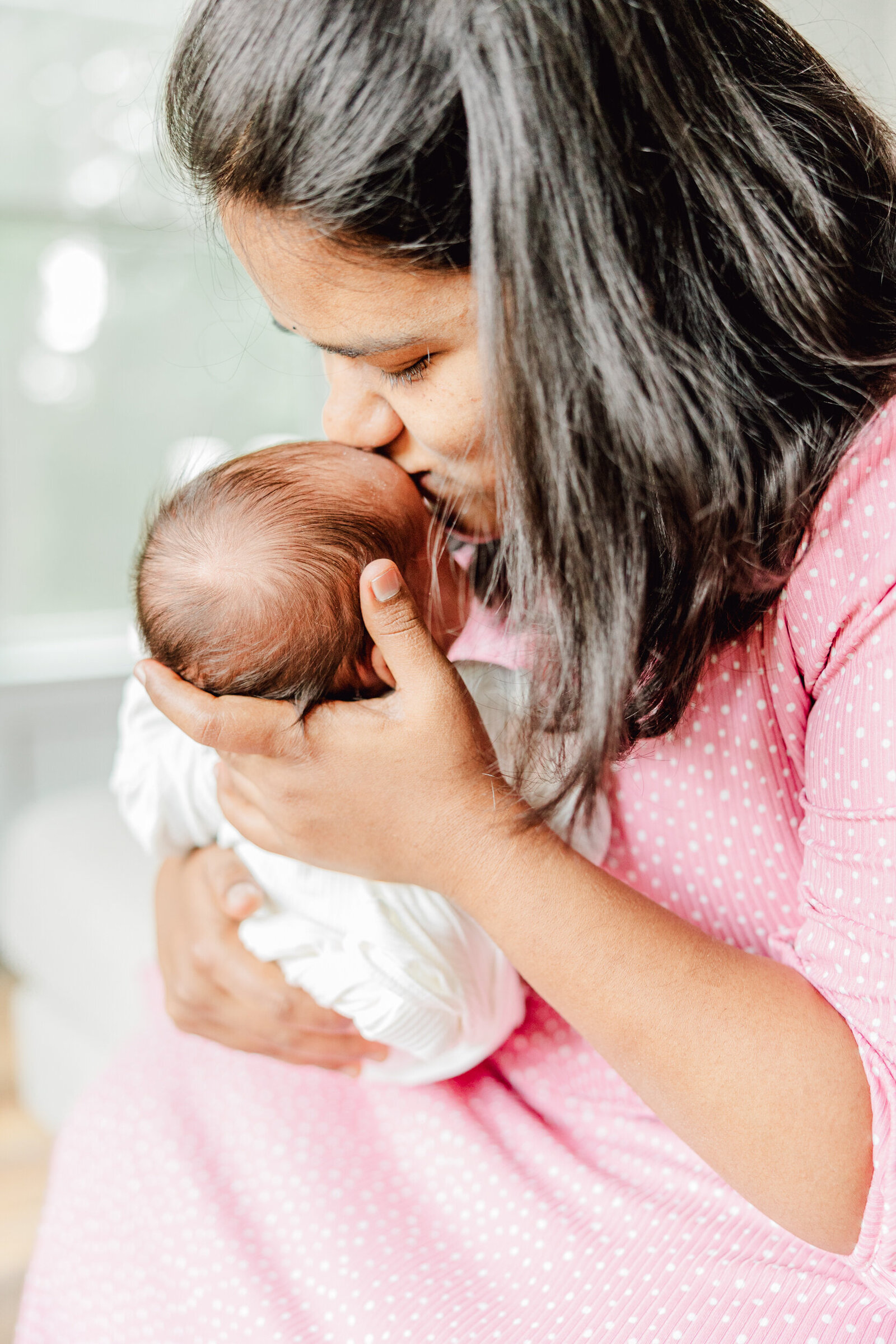 Mom kisses her newborn son