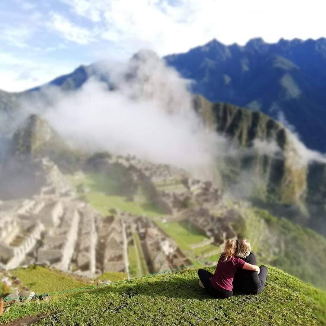 mielen paremminvoinnin ja kehomieliyhteyden valmentaja istuu vuorella katsoen vuorimaisemaa