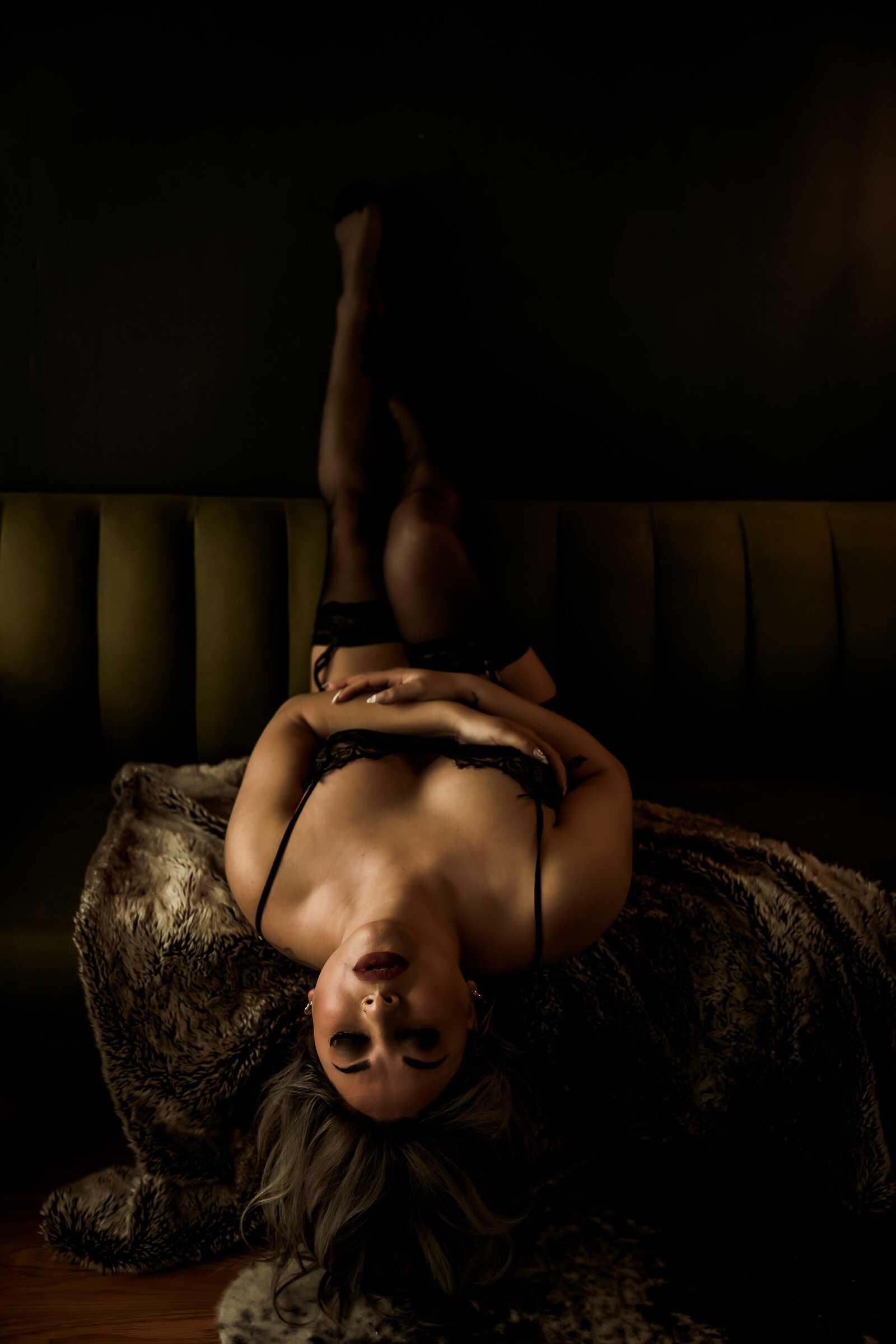 Laying upside down with eyes closed and legs up on the wall