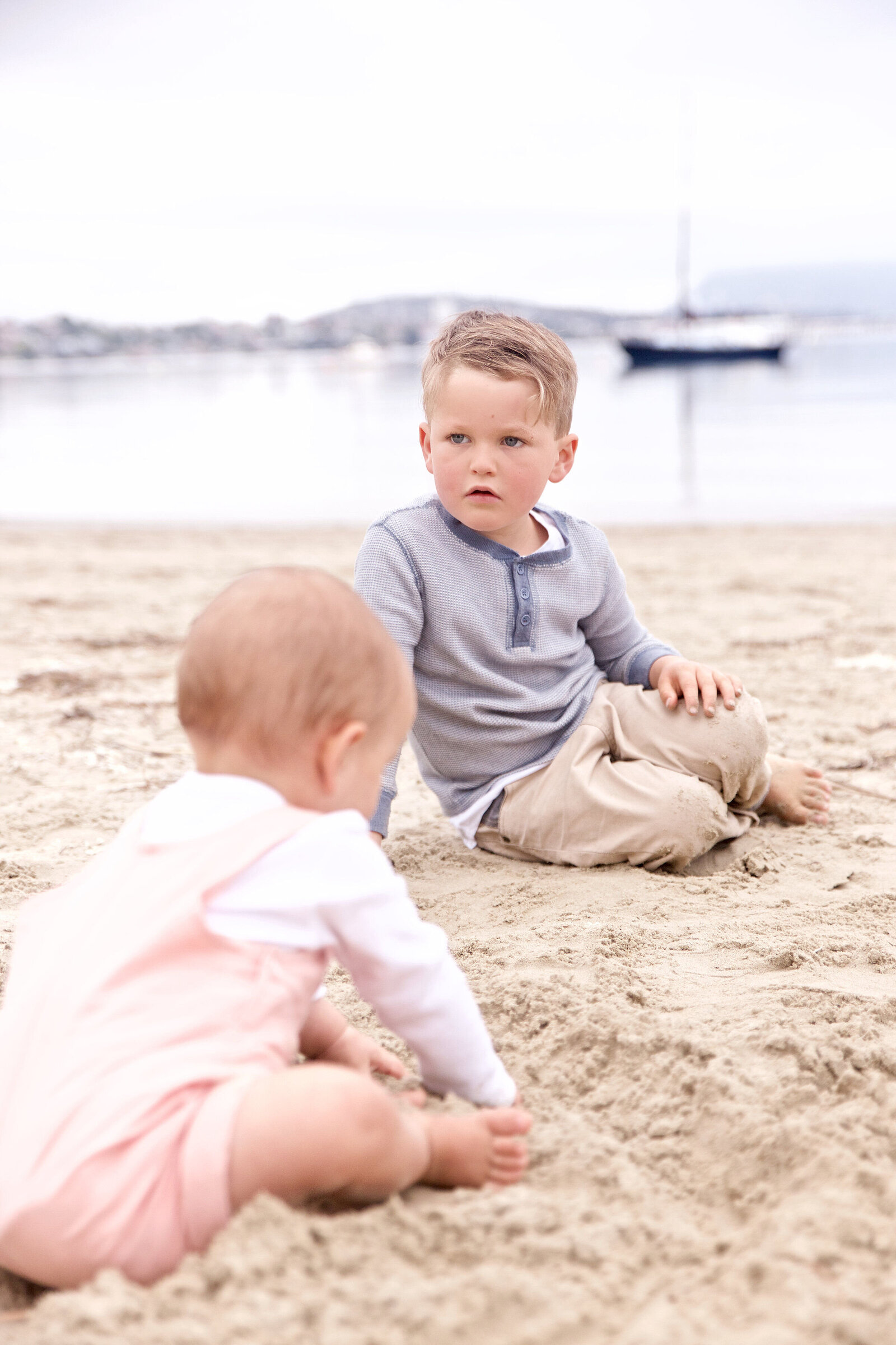 Two kids on the beach in cute cloths for a clothing photoshoot campaign