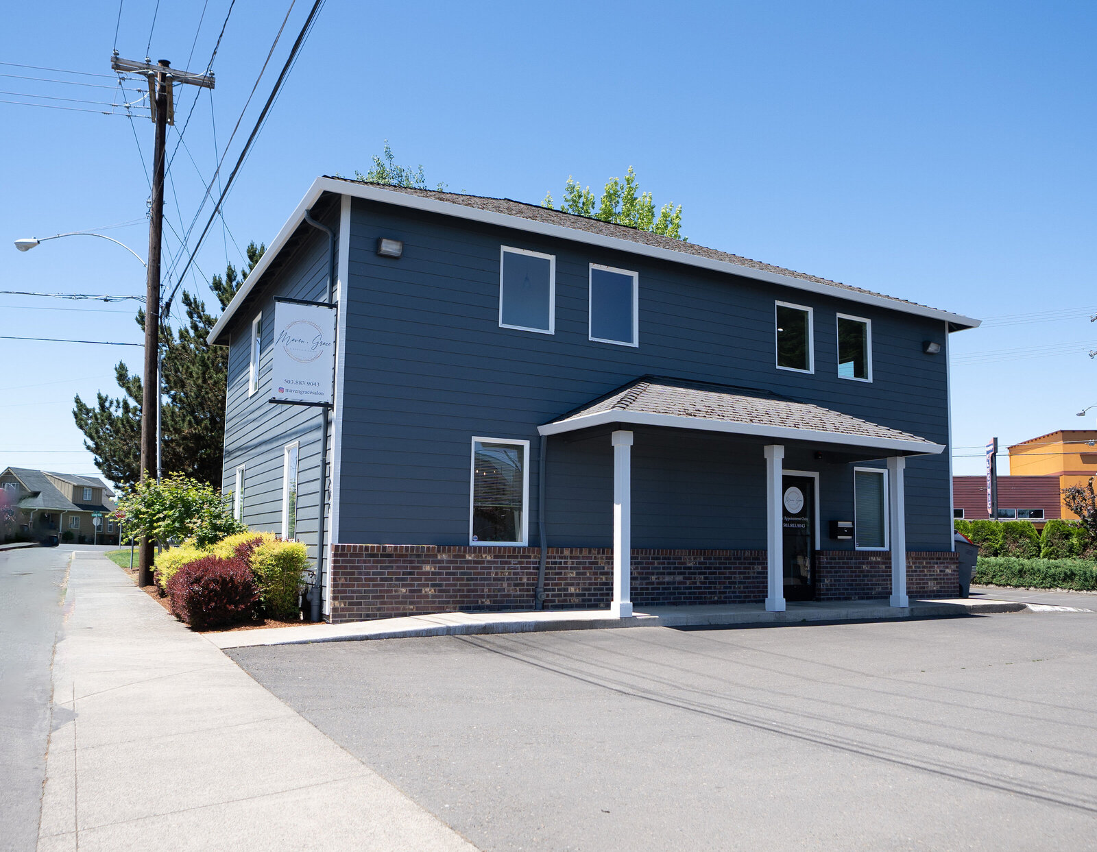Exterior of Maven + Grace Salon in McMinnville, Oregon, showing the building facade, signage, and private parking area
