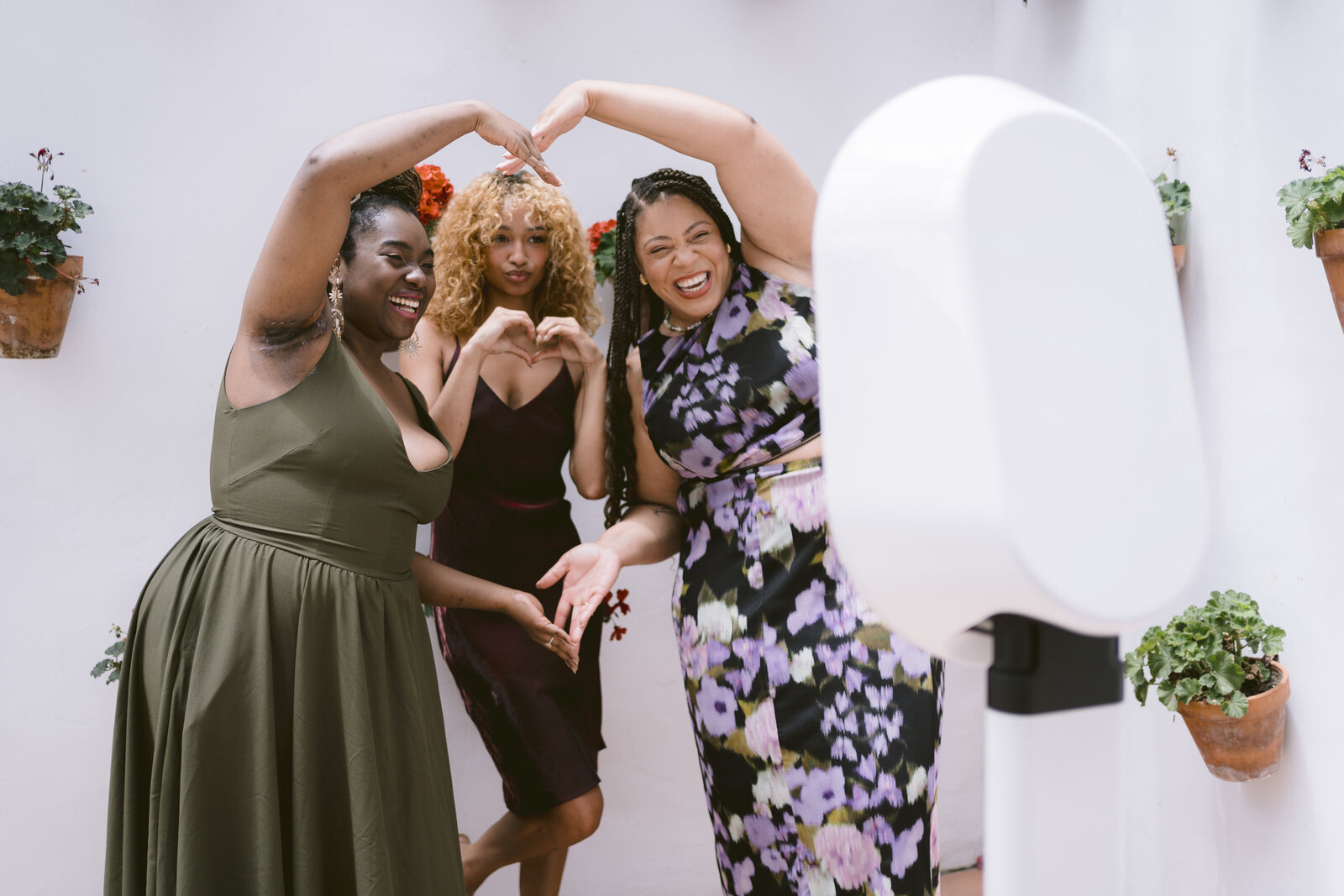 Group of friends laughing and posing with props in the photo booth at an event